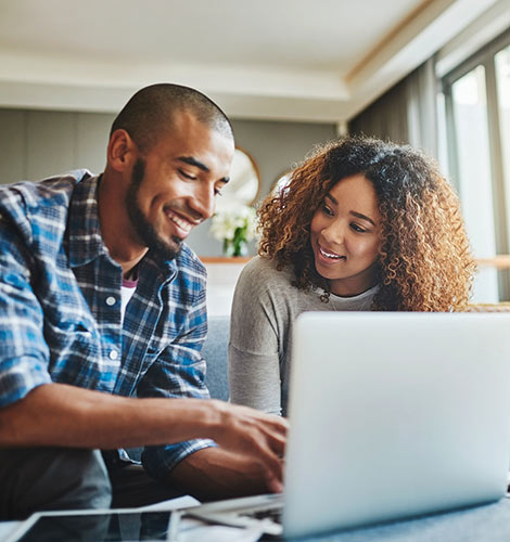 Young couple using laptop at home.