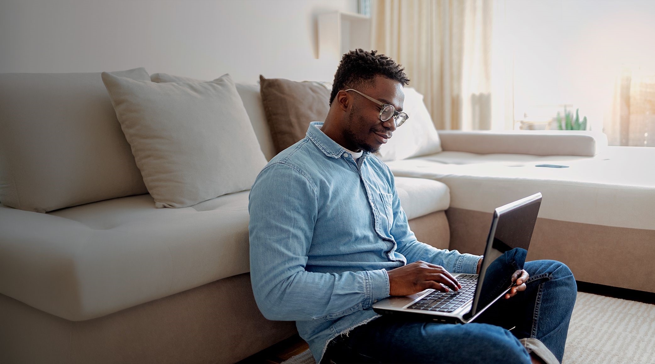 Man on laptop in living room. 